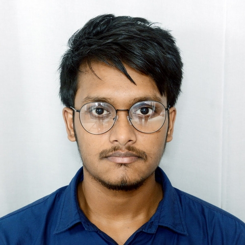 Sampad with glasses wearing a blue collared shirt