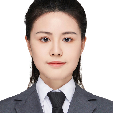 Woman in gray suit and black tie with badge on lapel